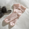 Blush Pink Supreme Cashmere Bed Socks styled in a bedroom 1 | Soak and Sleep