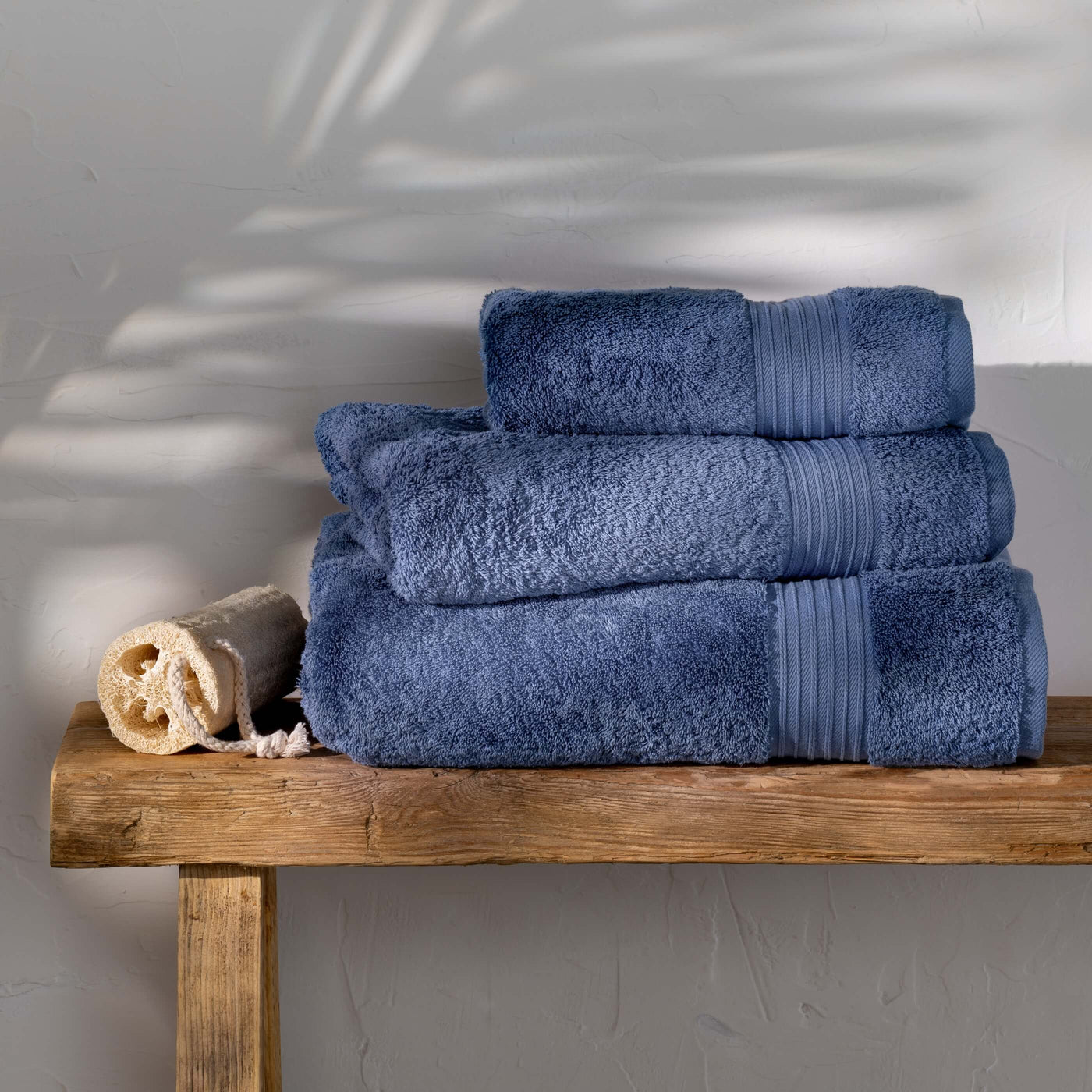 Dusky Blue Egyptian Cotton Towels styled in a bedroom | Soak and Sleep