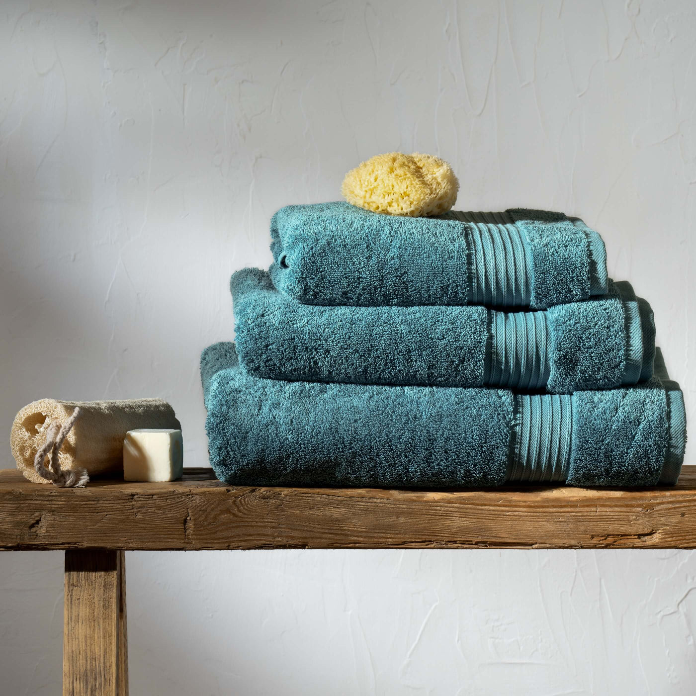 Teal Egyptian Cotton Towels styled in a bedroom | Soak and Sleep