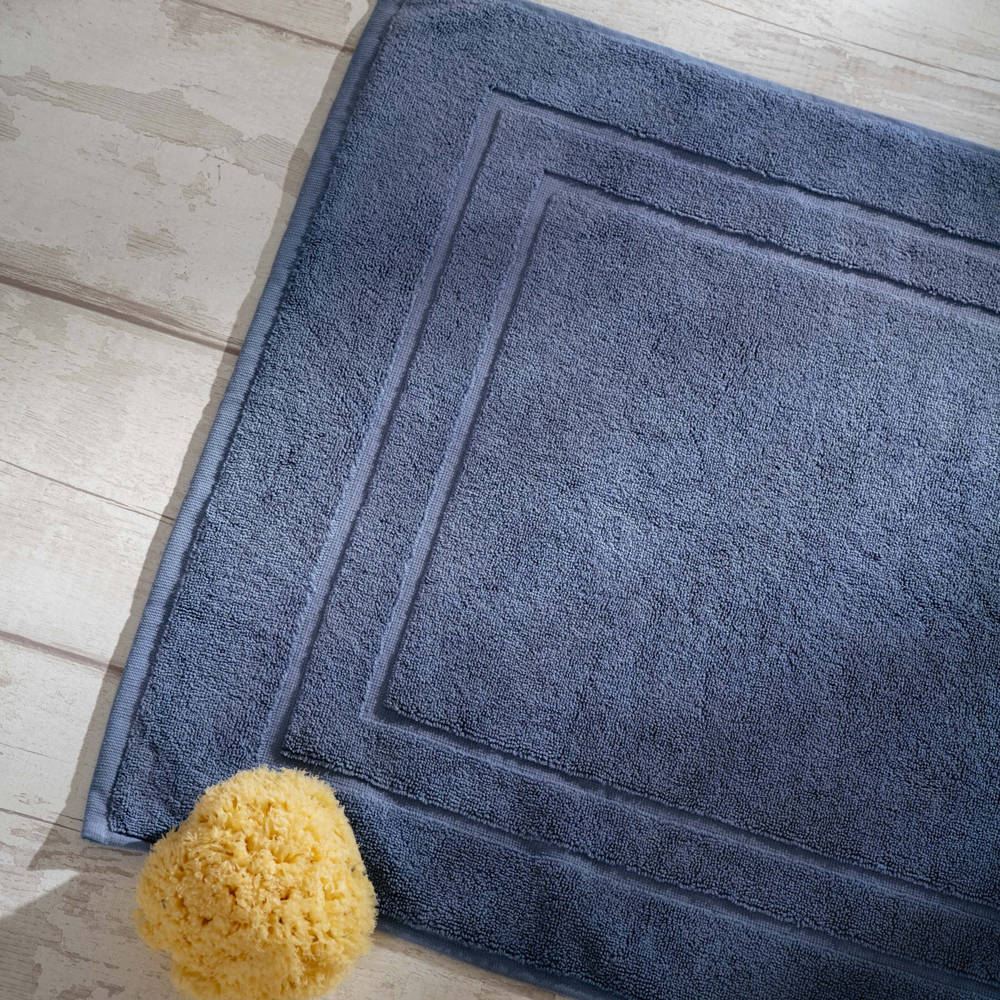 Dusky Blue Egyptian Cotton Bath Mat styled in a bedroom | Soak and Sleep
