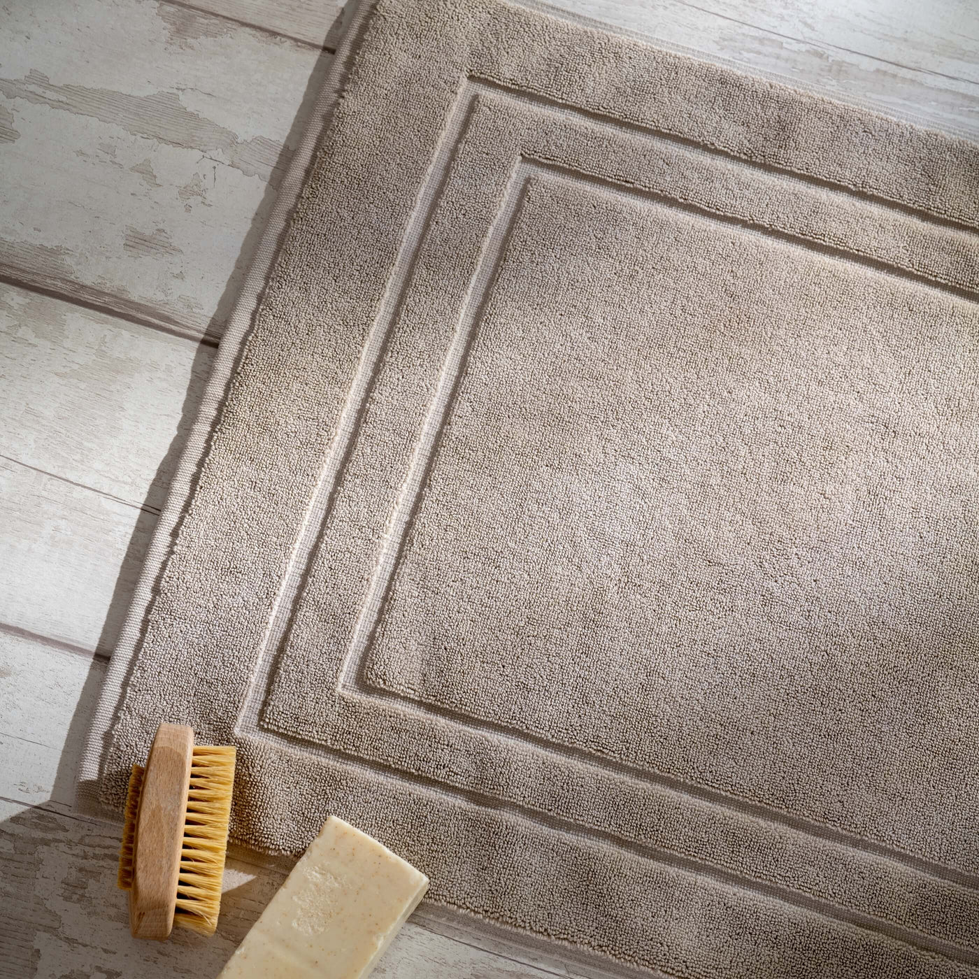Taupe Egyptian Cotton Bath Mat styled in a bedroom | Soak and Sleep