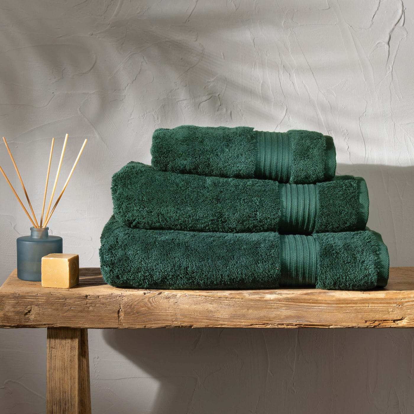 Dark Emerald Egyptian Cotton Towel Bale styled in a bedroom | Soak and Sleep