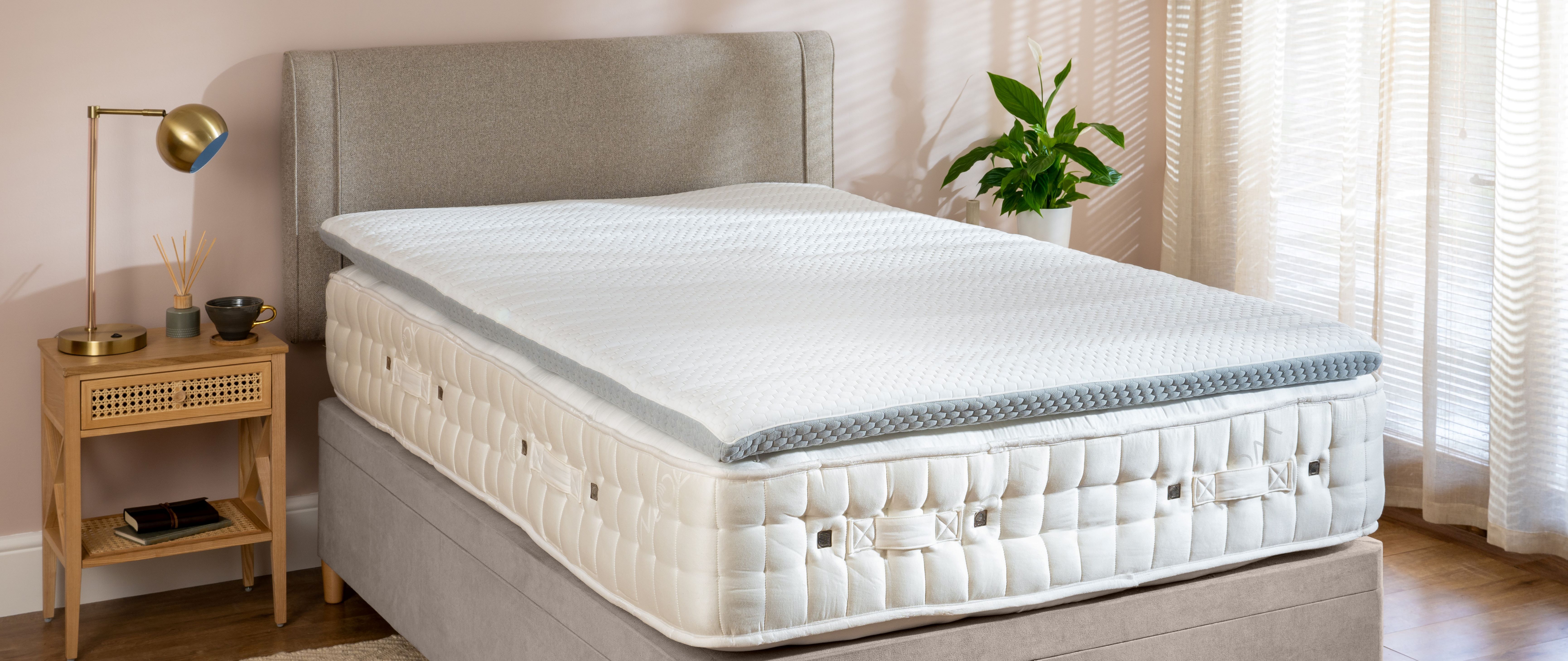 Soak&Sleep Cooling Memory Foam Topper, styled in a neutral styled bedroom with rattan furniture and brass accents.