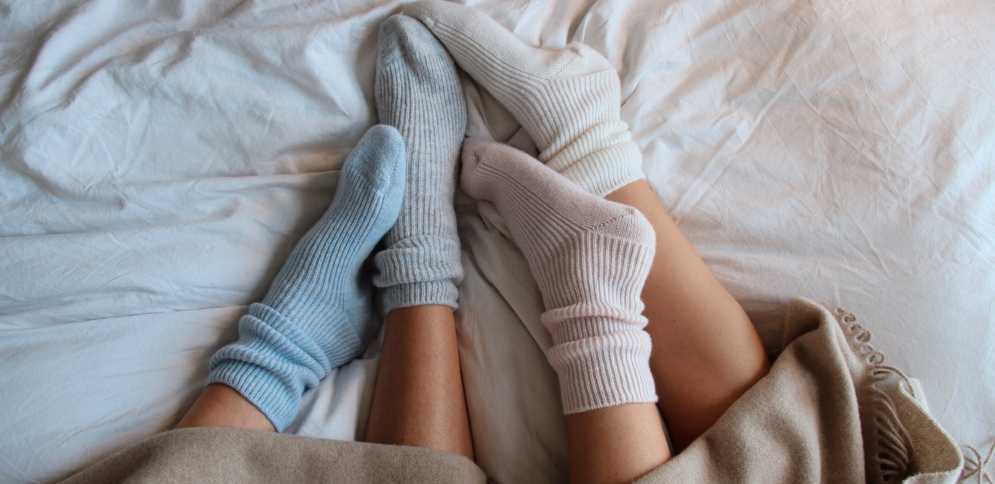 2 people wearing Soak&Sleep cashmere socks in 4 colours