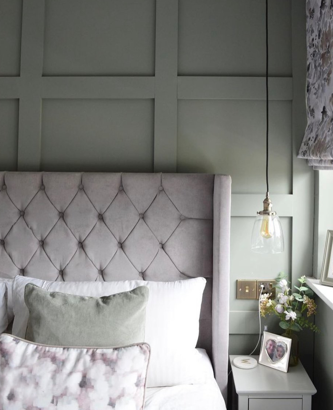 Light green panelled bedroom with light purple headboard and curtains and hanging pendant light. Ft Soak&Sleep pillows