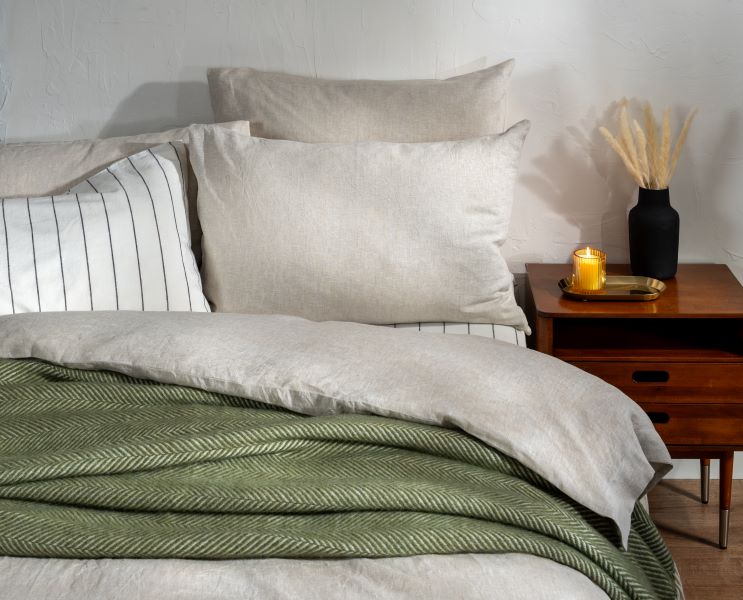 Soak&Sleep's Natural Marl French Linen bedding, styled with Pinstripe linen cotton blend and an Olive Green Herringbone Pure Wool throw