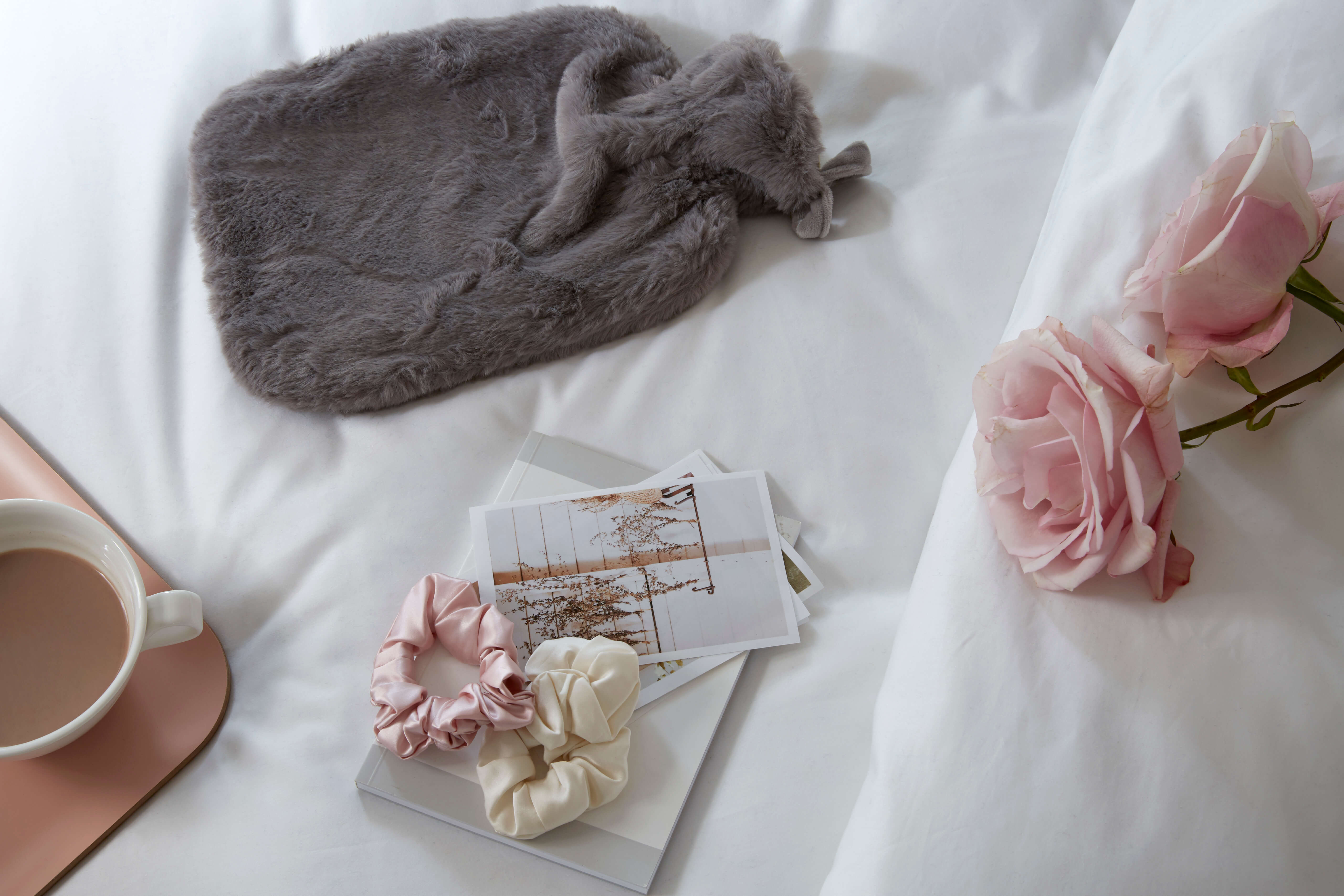 Flat lay image of Soak&Sleep midnight grey hot water bottle & silk scrunchies