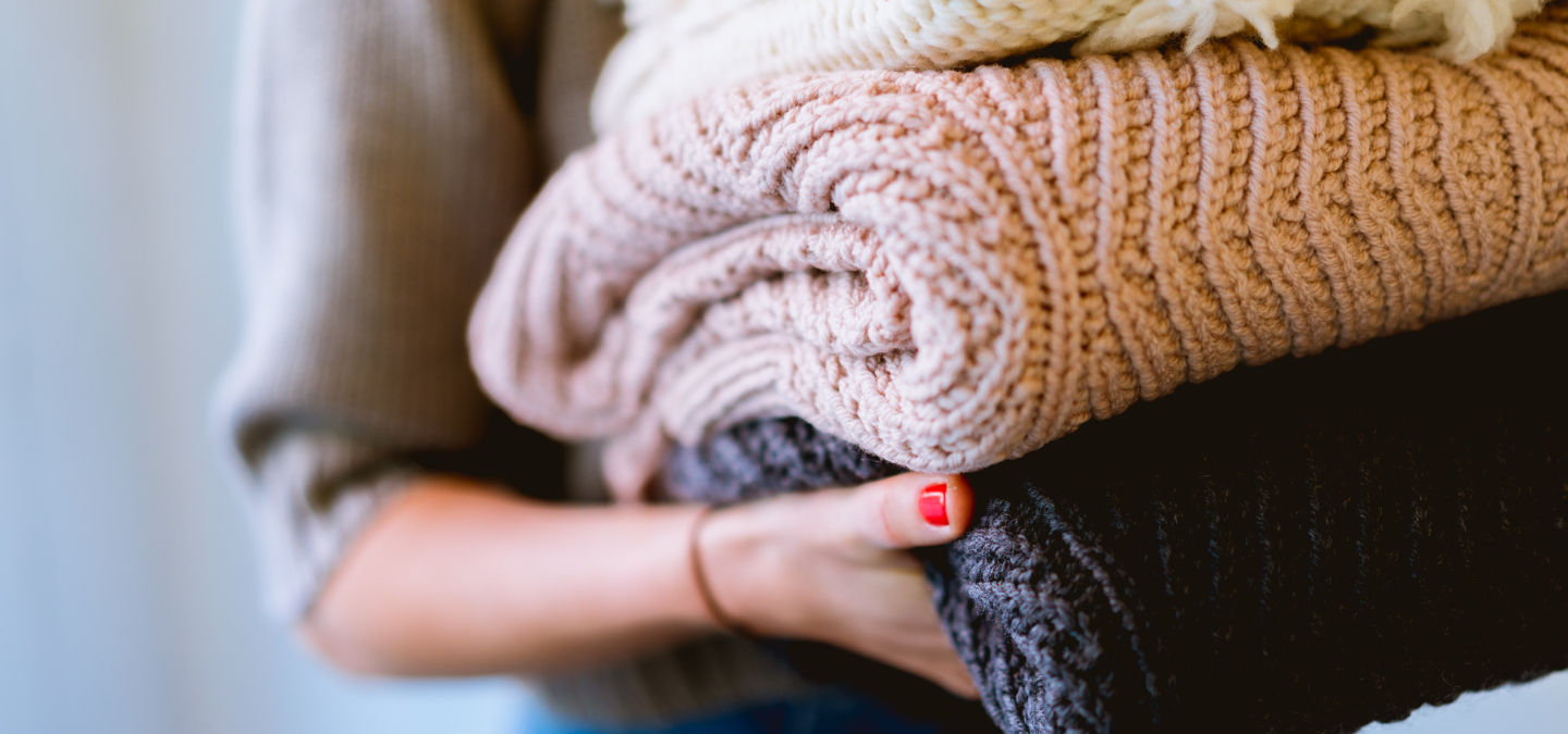 Person carrying folded blankets