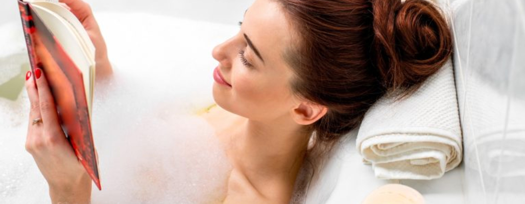 Woman reading in a bubble bath