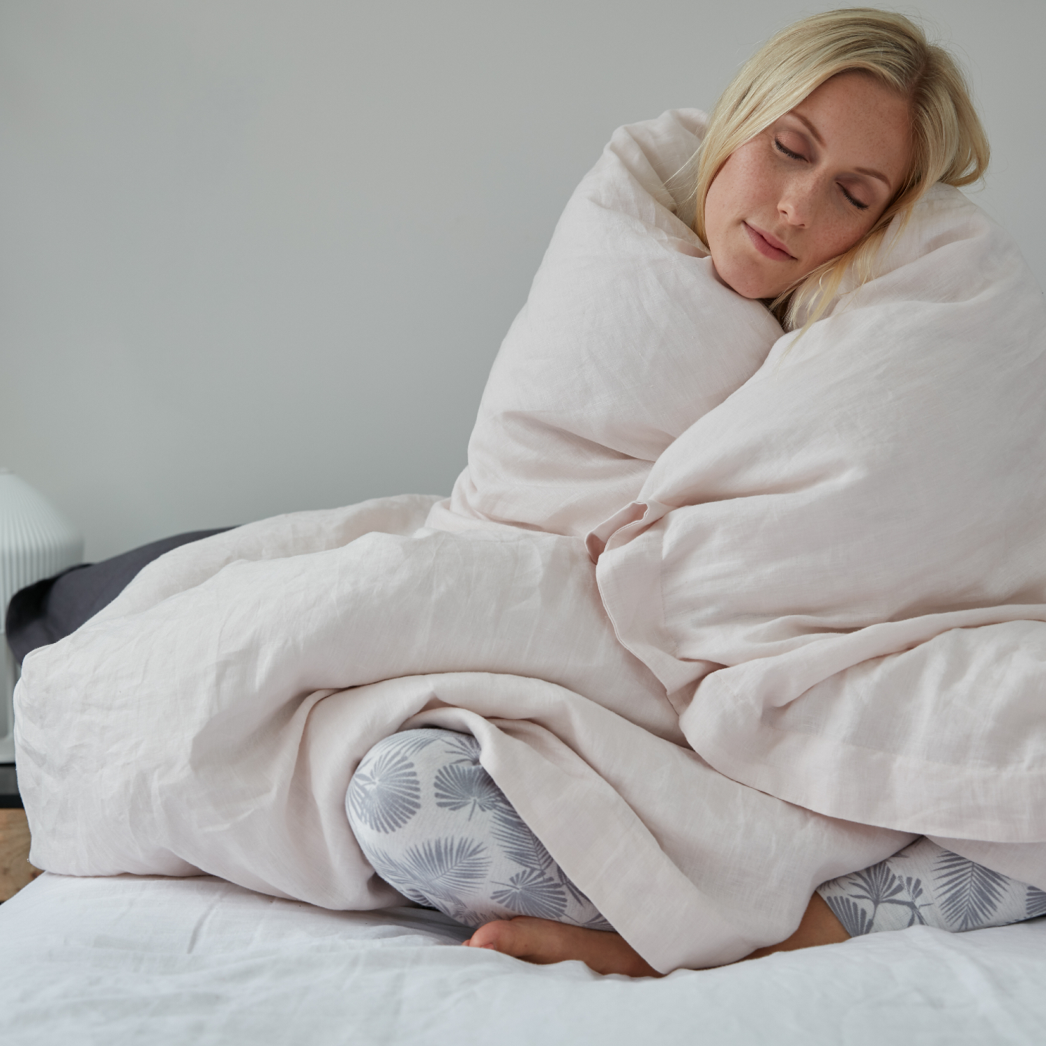 Woman wrapped up in loft, cosy duvet