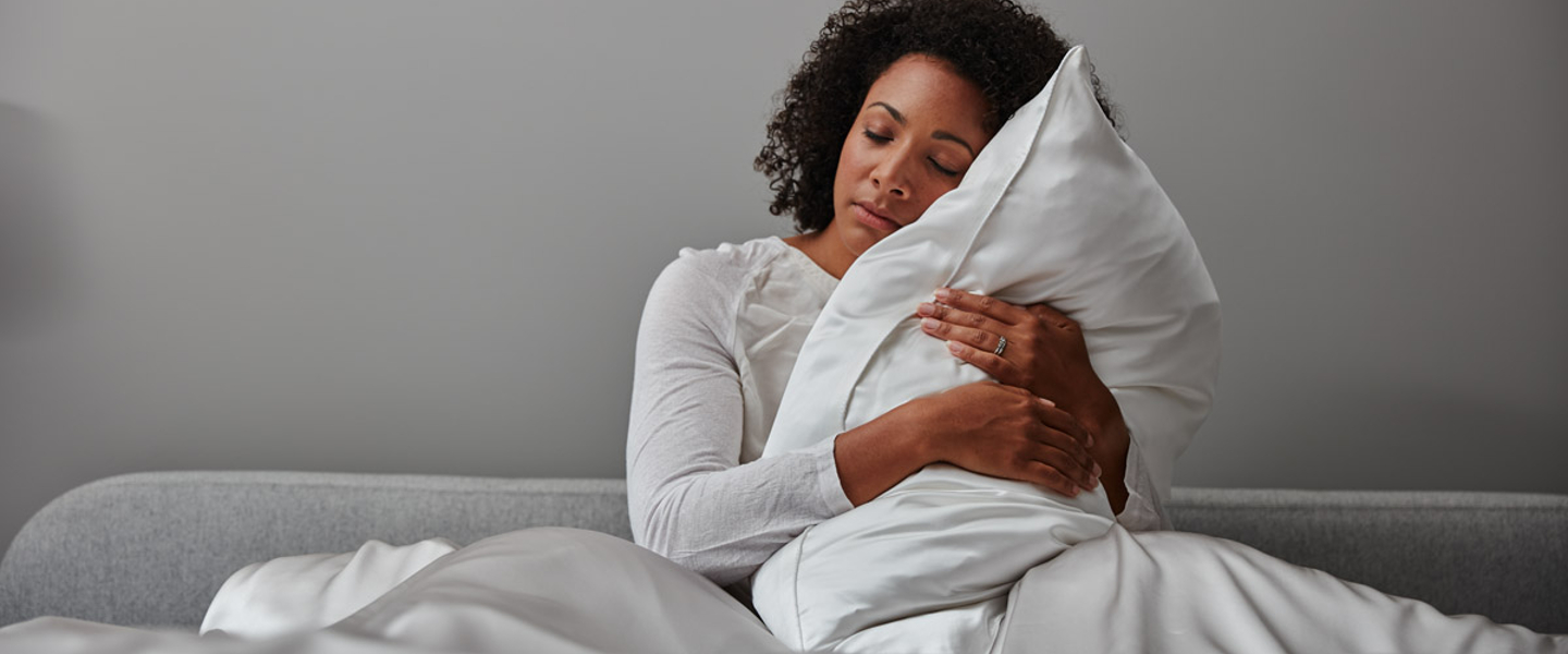 Woman hugging Soak&Sleep Pillow