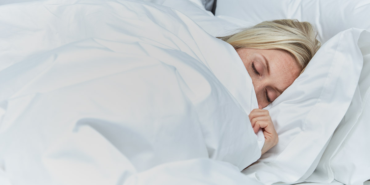 Woman curled up in Soak&Sleep duvet